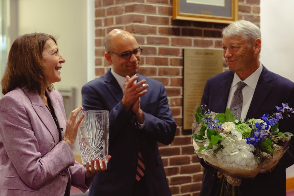 Allen looks at Mayor Wilson and Lisa Chimento, holding his award. 
