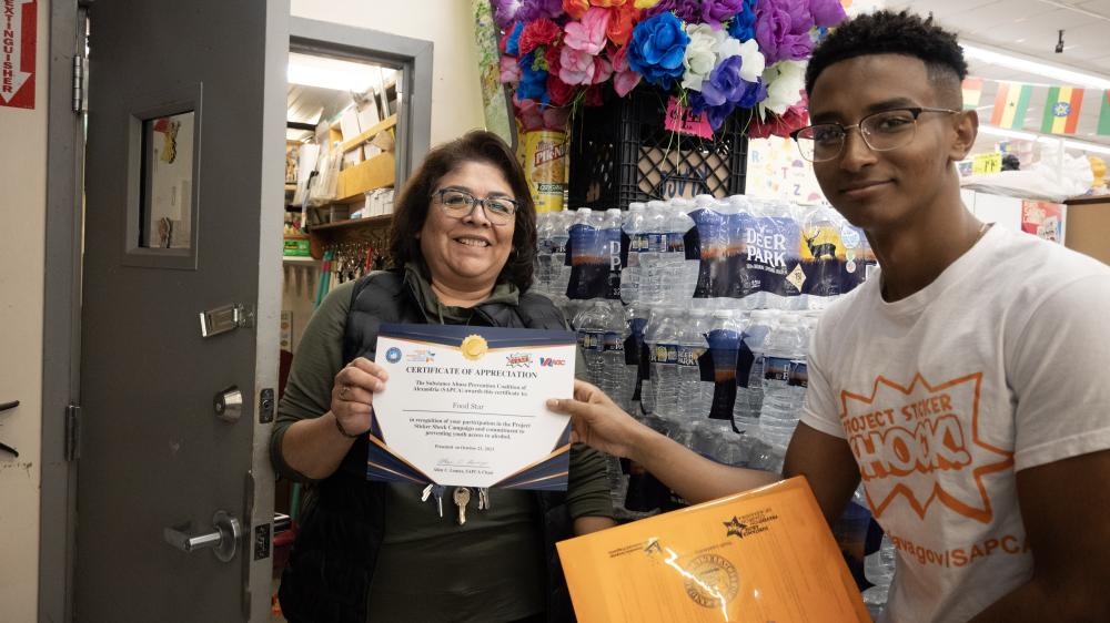 Student presenting certificate of appreciation to Food Star