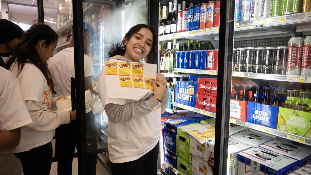 Student holding Project Sticker Shock stickers