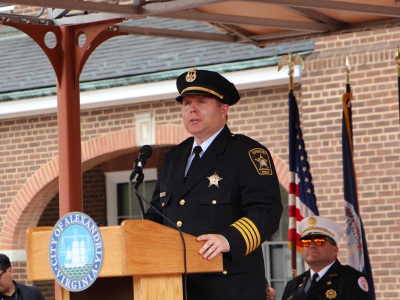 Sheriff wearing formal uniform speaking at podium at outdoor event