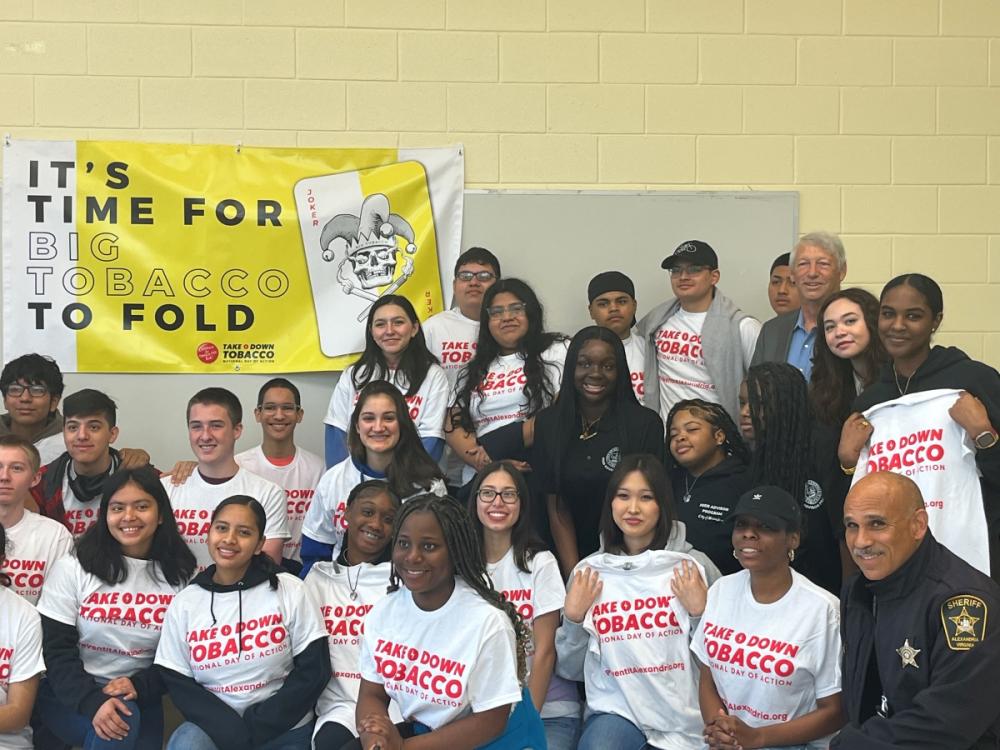 Several teens wearing t-shirts that say Take Down Tobacco joined by a few adults including a deputy in uniform