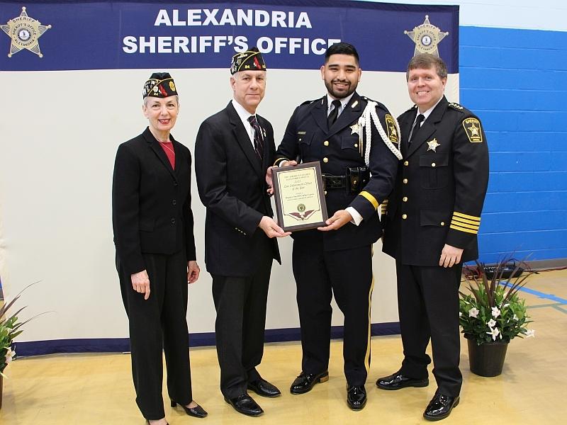 Two military retirees, deputy and sheriff with deputy holding an award plaque