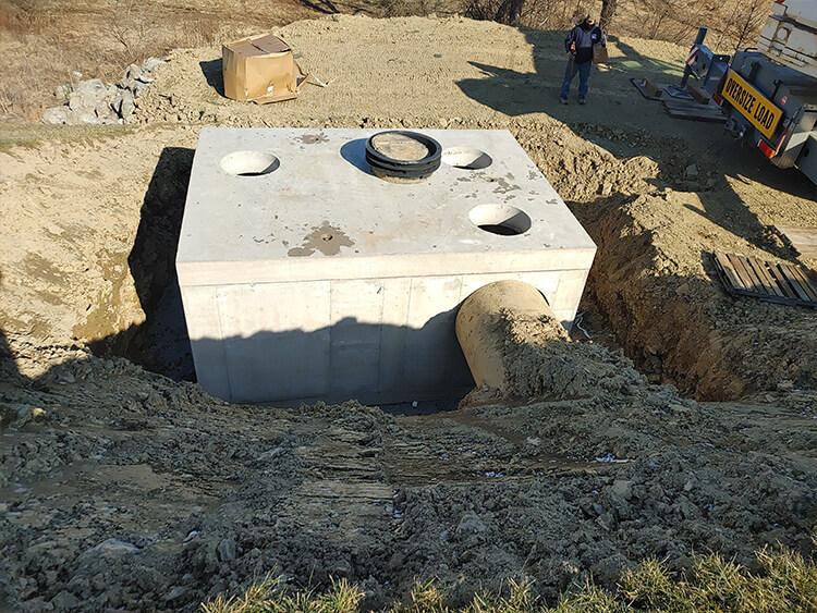 Photo of massive concreate structure sitting in excavated hole in the ground.
