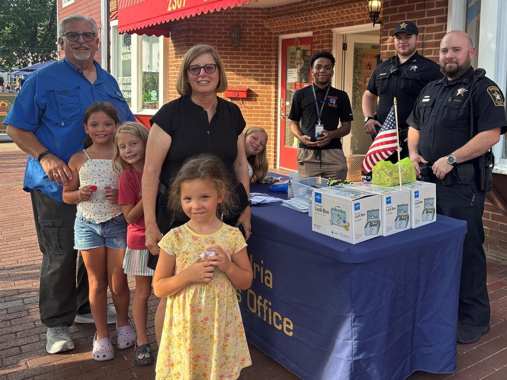 family with children and deputies with teen employee at community event