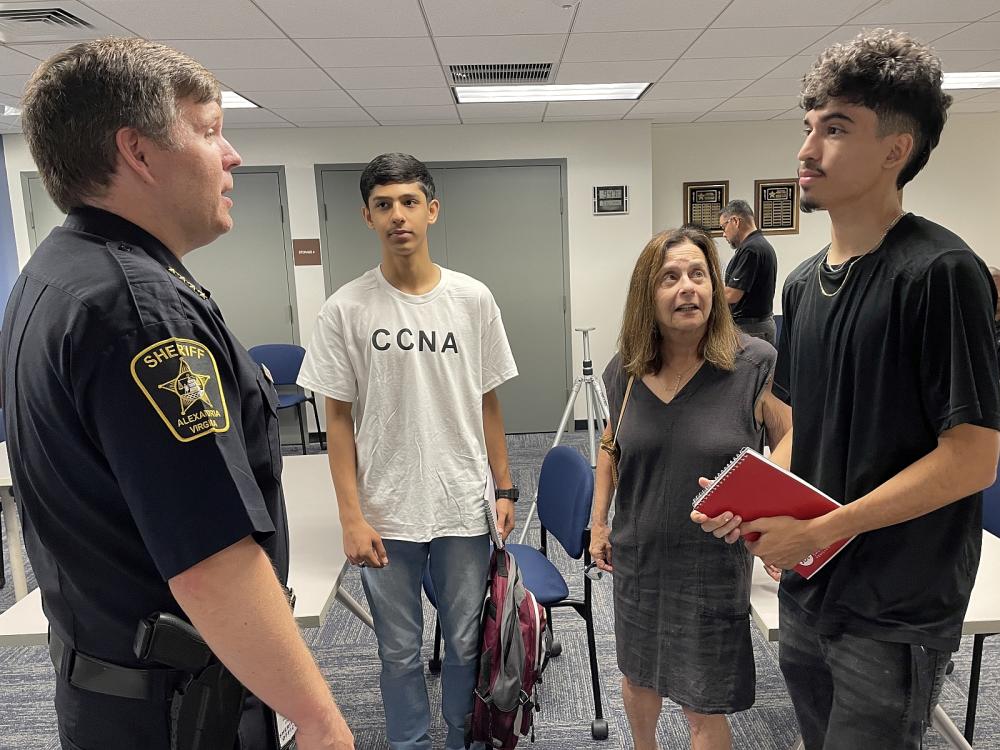 Sheriff speaking with two young men and a woman in a room at the Sheriff's Office
