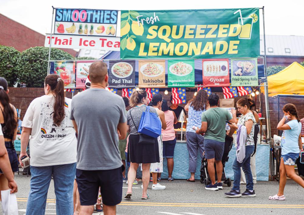 A group of people line up at the vendor booths