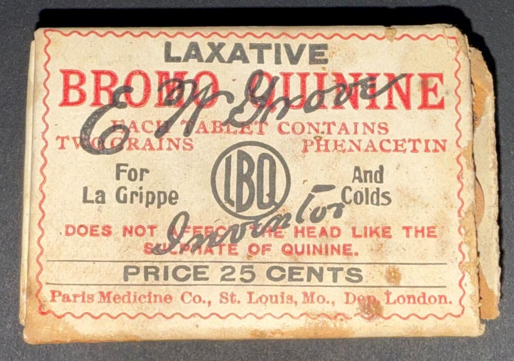 Small 2.5 by  1.5" yellow-ish box that reads "Laxative Bromo Quinine each tablet contains two grains phenacetin. For La Grippe and Colds. Does not effect the head like the sulphate of quinine. Price 25 cents. Paris Medicine Co., St. Louis, Mo. Dep. London. Box contains small round brown tablets.