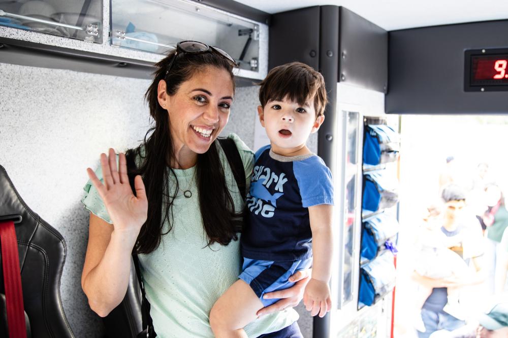 Mother and child smiling inside a firetruck