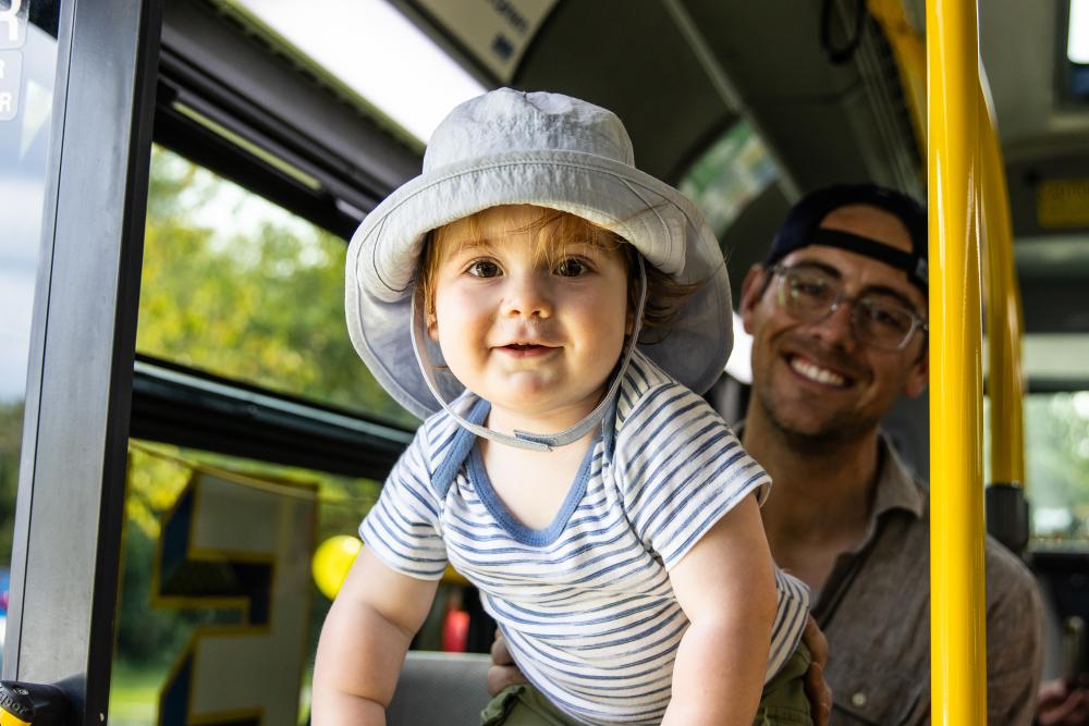 Smiling child with his parent on a bus