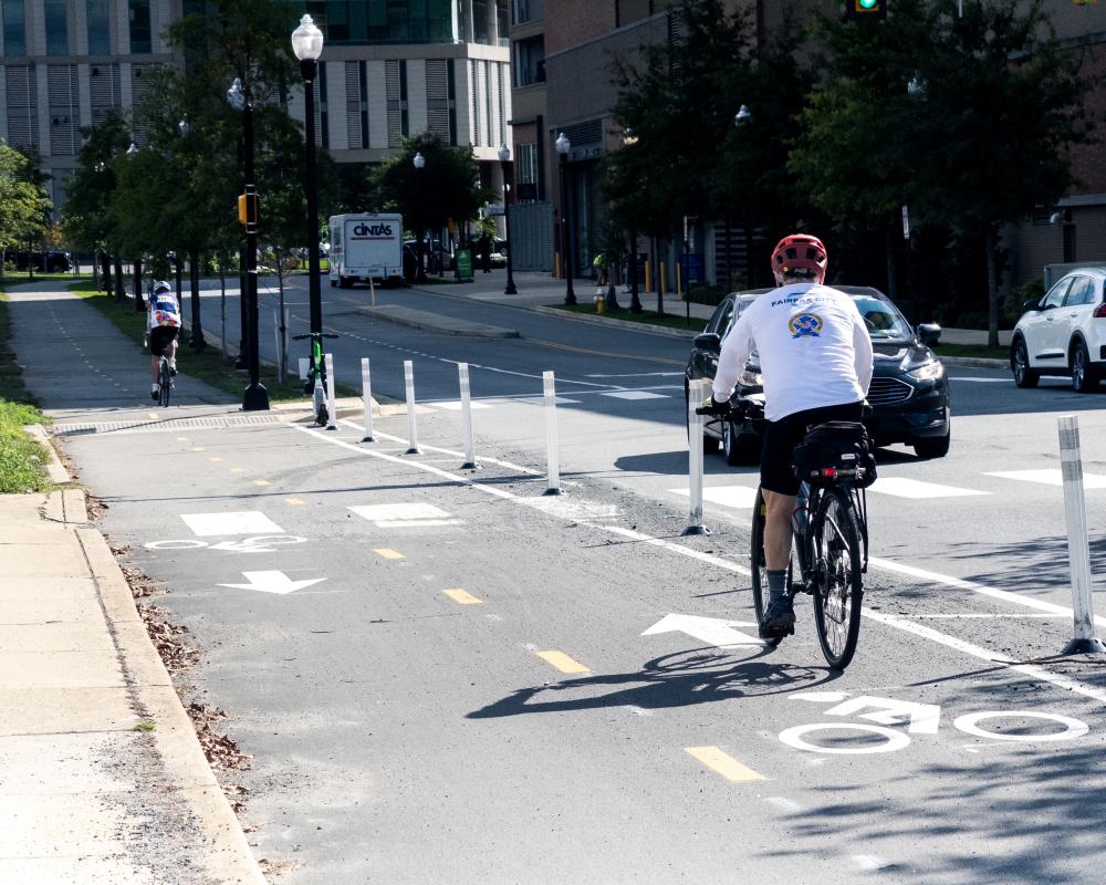 People biking on the new Mill Road bi-directional bike lanes.
