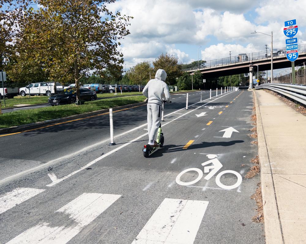 Person riding scooter in new Mill Road bike lane. 