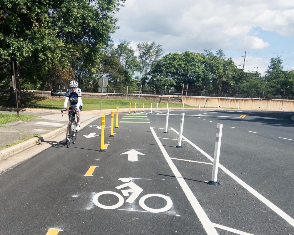 Person biking on Mill Road near Telegraph Road ramp at Pershing Avenue.
