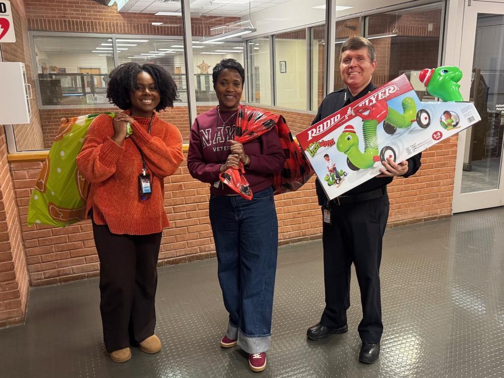 Sheriff and two civilian employees carrying children's holiday gifts