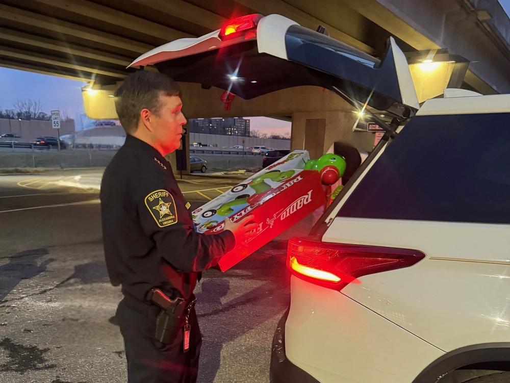 Sheriff loading toys into back of a car