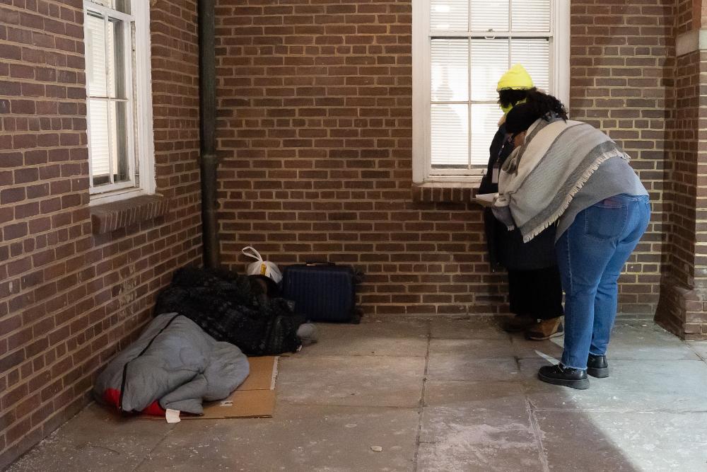 Photo of person who is homeless in sleeping bag outside