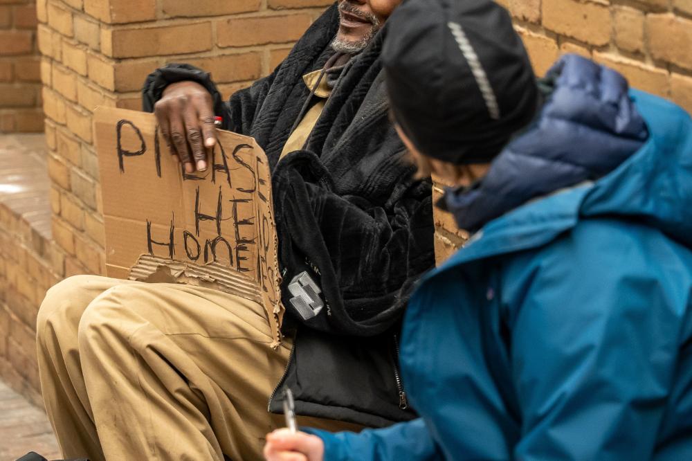 man holding please help sign