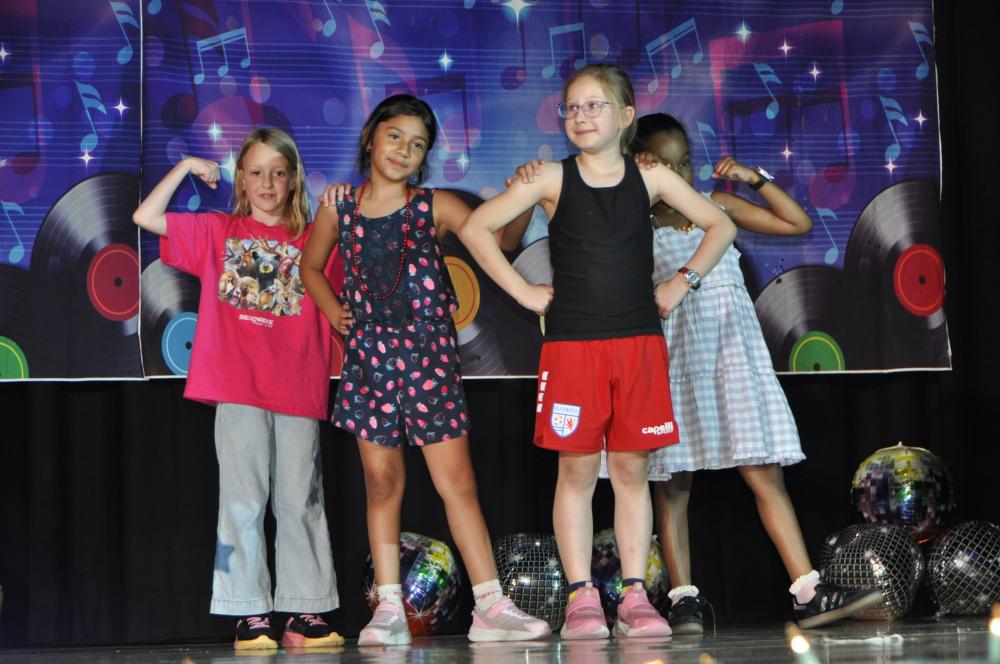 Four kids dressed in casual clothes on the stage