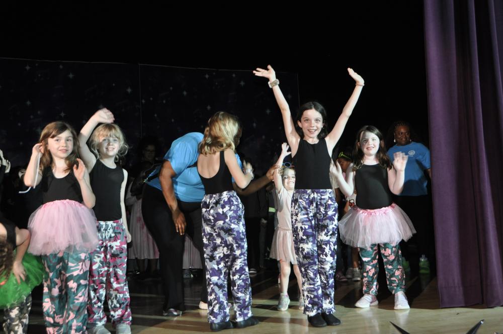 Kids smiling and waving at the crowd