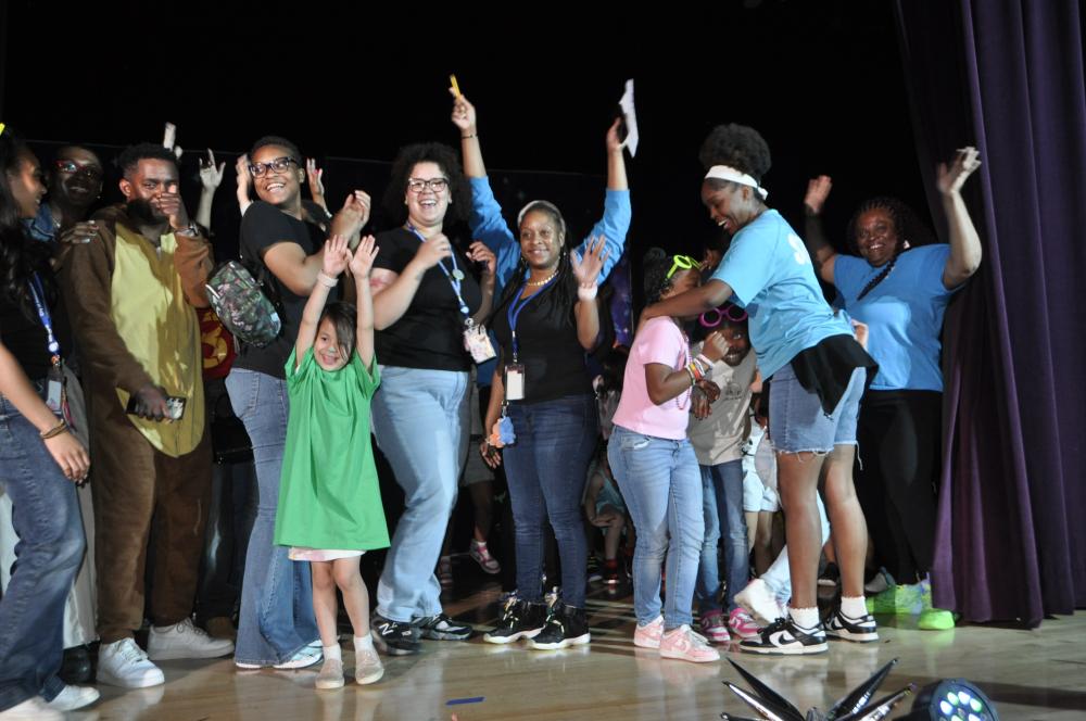 City staff and kids having fun and smiling while on stage