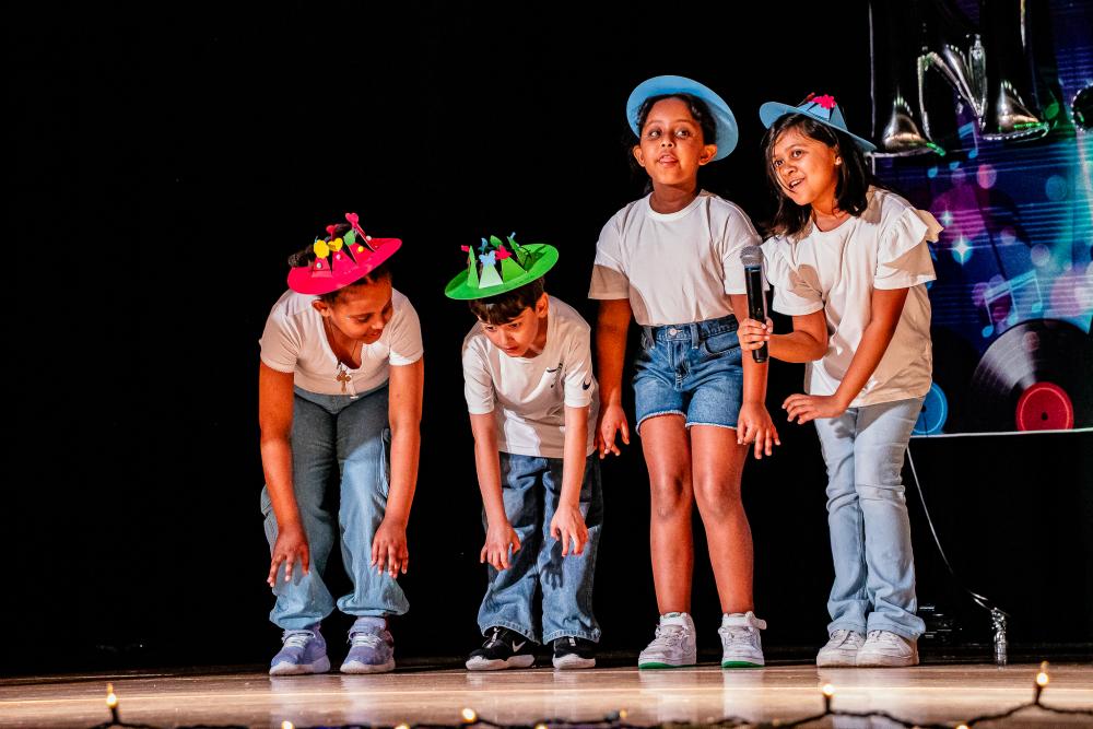 Performers wearing white shirts and jean bottoms and colorful hats