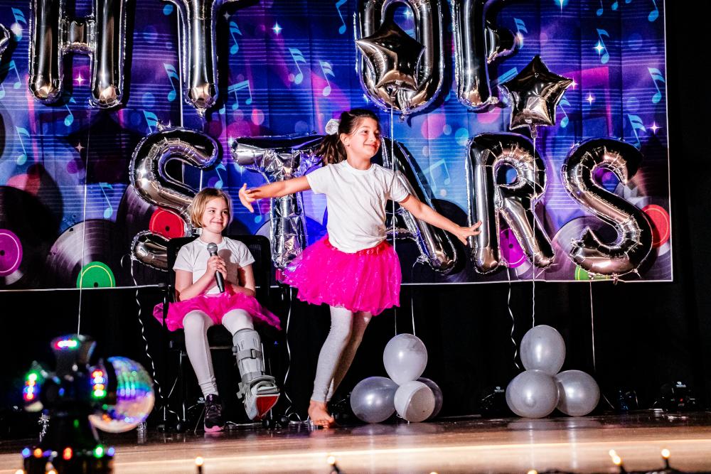 Performers wearing white shirts and pink tutus