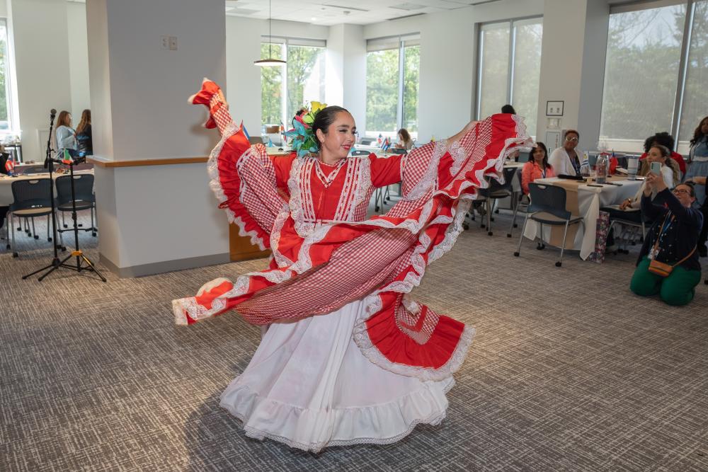 woman in red and white dress dancing in room with others watching