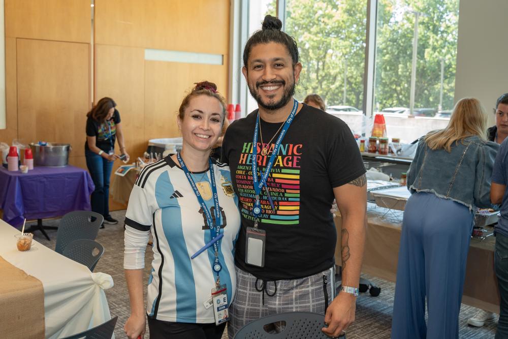 man and woman standing next to each other smiling at camera