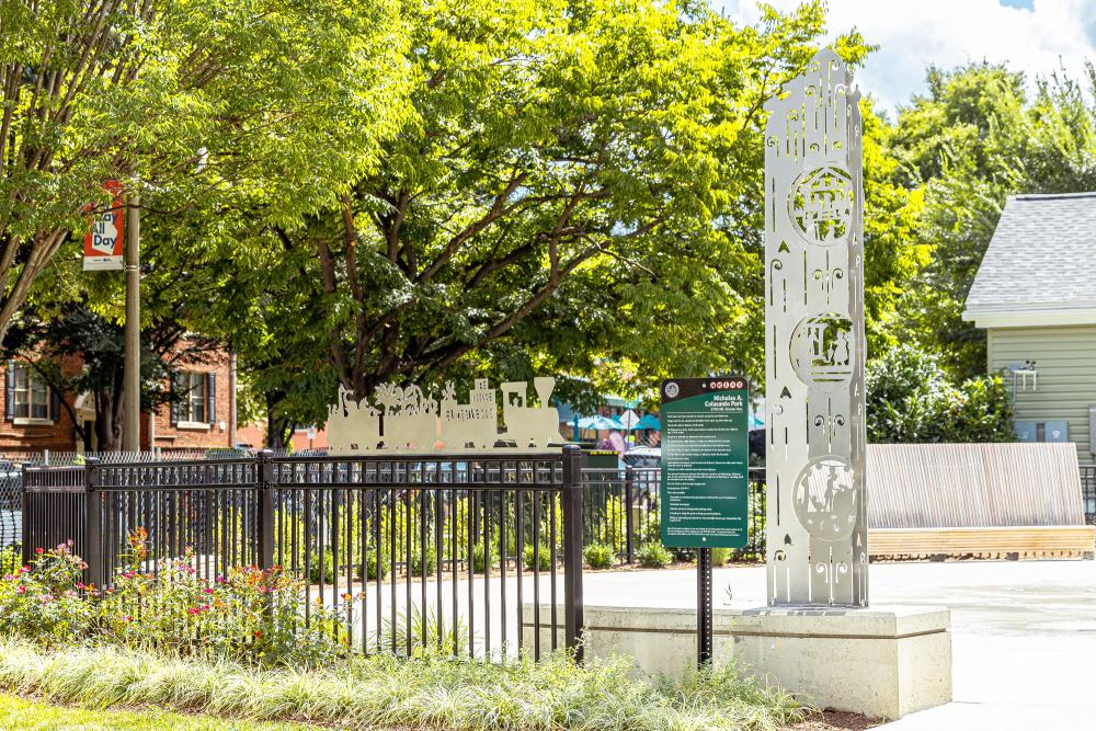Colasanto park public art with black fencing next to it