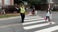 sheriff directing traffic with kids in crosswalk