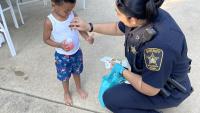 deputy giving a small child a badge sticker