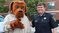 mascot in a dog costume and sheriff in uniform