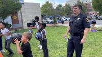 sheriff watching as kids shoot basketballs