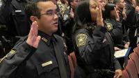 deputies in uniform holding their right hands up to take an oath