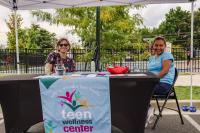 Volunteers from the Teen Wellness Center are sitting and smiling
