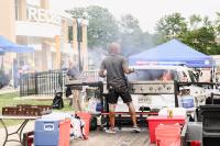 A man grilling burgers and hotdogs