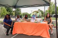 Volunteers from Substance Abuse Prevention Coalition of Alexandria sit and smile