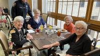 sheriff standing with four seniors seated at dining table for lunch