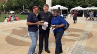 Sheriff standing in between two women, everyone smiling, at a community event
