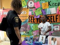 Deputy sheriff speaking with young author about her book at a school event