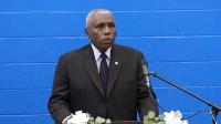 Man in suit speaking at podium with Sheriff's star in front