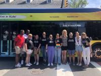 Group of people posing in front of pride bus