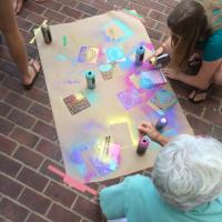 A group of artists collaborate on a spray painted project. 