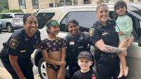 Sheriff's commander in blue uniform, Sheriff's sergeant in blue uniform and Police officer in gray uniform with three kids, all smiling