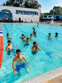 Image of teens swimming at an outdoor pool