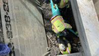 Contractors install the new turquoise SDR pipe in a supported trench