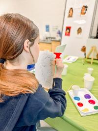 Teenage girl painting on a canvas