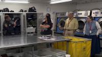 In a jail laundry room, deputy speaks with four community members on a tour