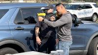 Deputy showing a community member how to deploy a training round in a pepperball launcher
