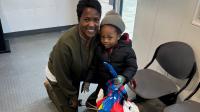 Civilian staff member with small child and holiday gift bag