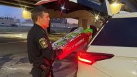 Sheriff loading toys into back of a car